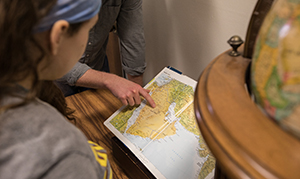 students looking at a map with globe sitting beside them
