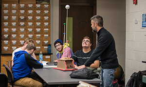 student and professor inside classroom doing experiment