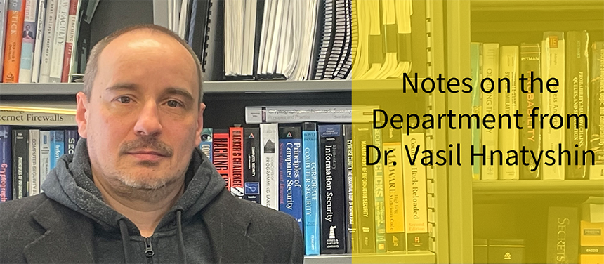 A photograph depicting Dr. Vasil Hnatyshin standing in front of the bookcase in his office. Dr. Hnatyshin is a white man with salt-and-pepper hair and a partial beard. He is standing to the left, not smiling. He is wearing a gray sweatjacket with a black suit jacket on top. The right half of the image is taken up by a bright, slightly opaque yellow box. On it is text that reads, "Notes on the Department from Dr. VH."