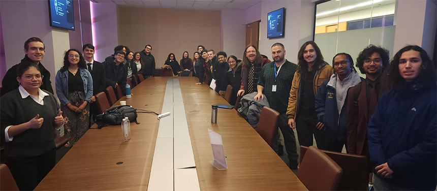 A group photo of many CS students in a Microsoft corporate meeting room.