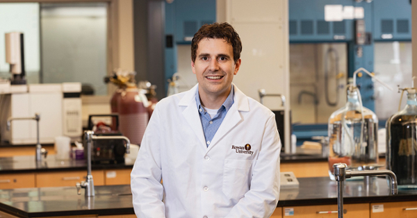 James Grinias, Ph.D, in a white lab coat