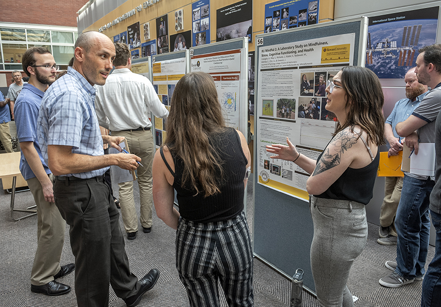 students and faculty viewing posters at research conference