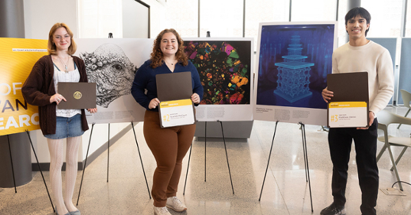 From left, Rylie Jacobs, Scarlett McCourt and Matthew Heras display their award-winning work during Rowan Research Day at the Student Center in March.