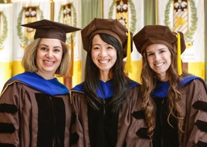 three female doctoral students at commencement
