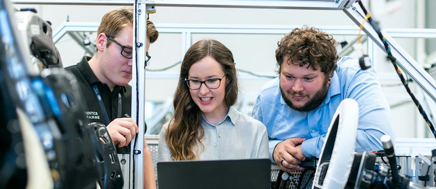 Three people working on a car prototype