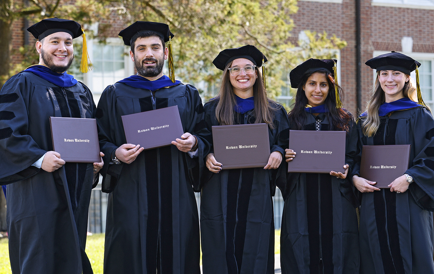 first group of phd graduates standing together at graduation