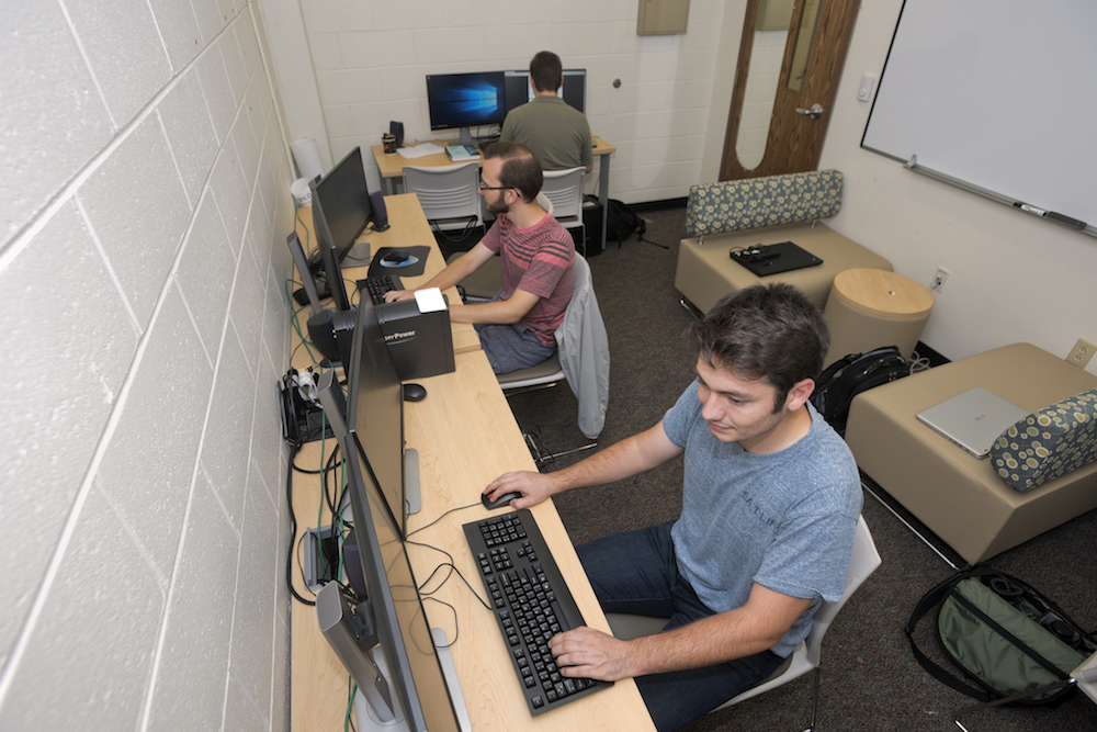 Three students working in a computer lab