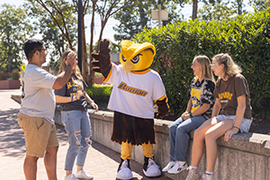 group of students outside with owl mascot