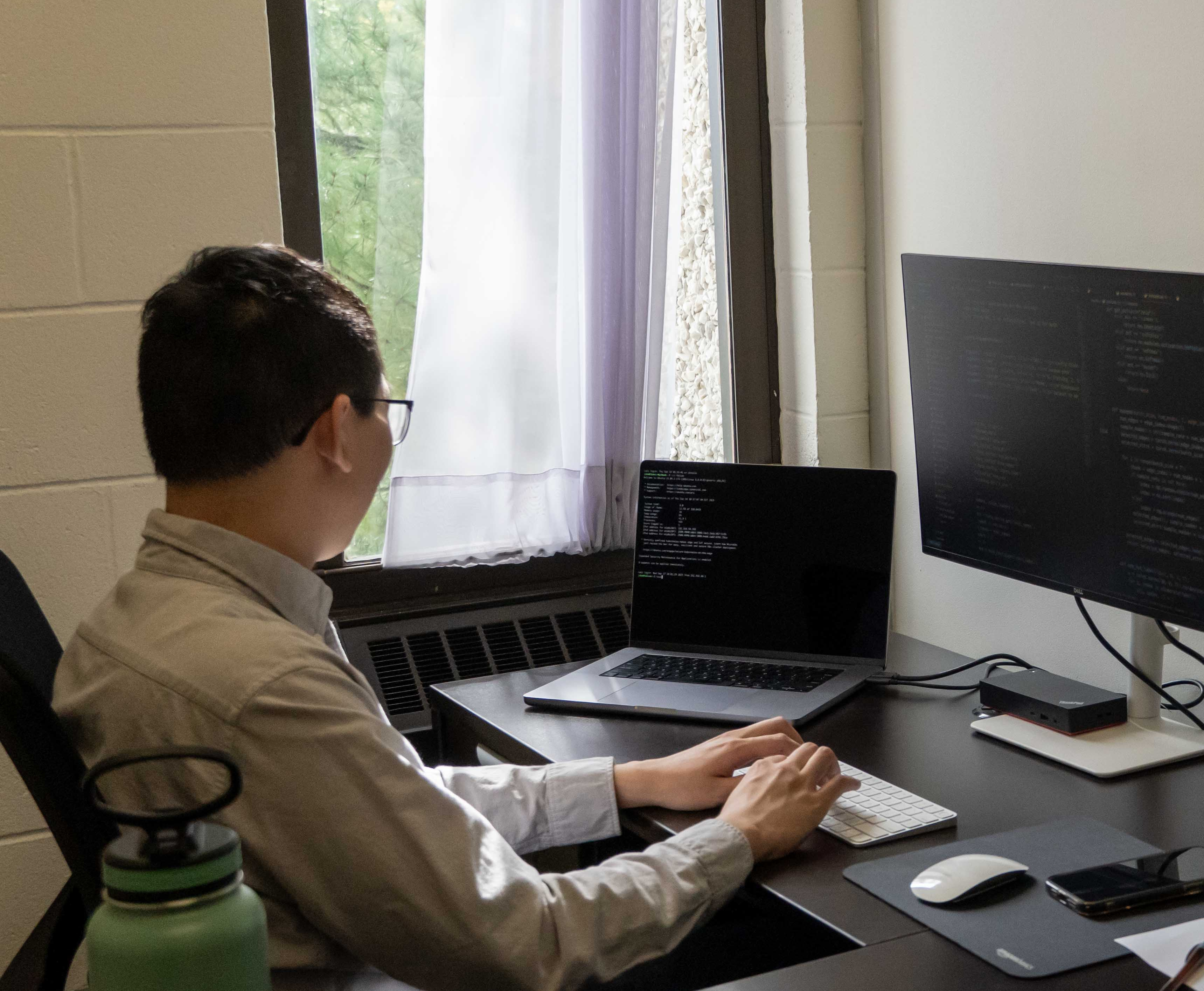 Dr. Jiang sits at his desk in his office, working hard.